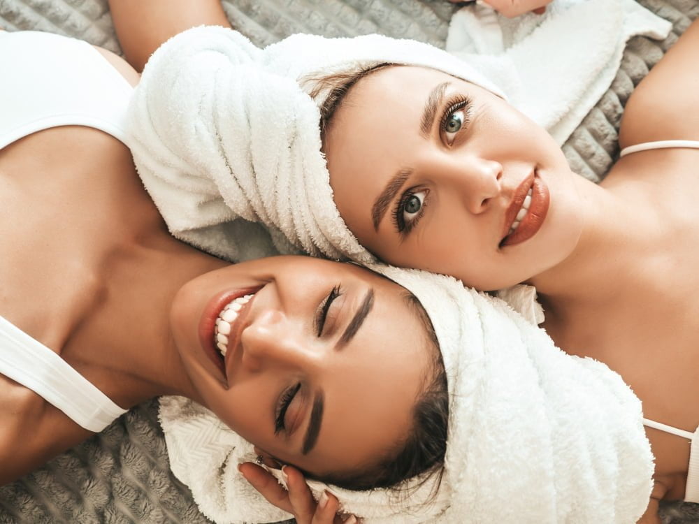 two-young-beautiful-smiling-women-white-bathrobes-towels-head.jpg